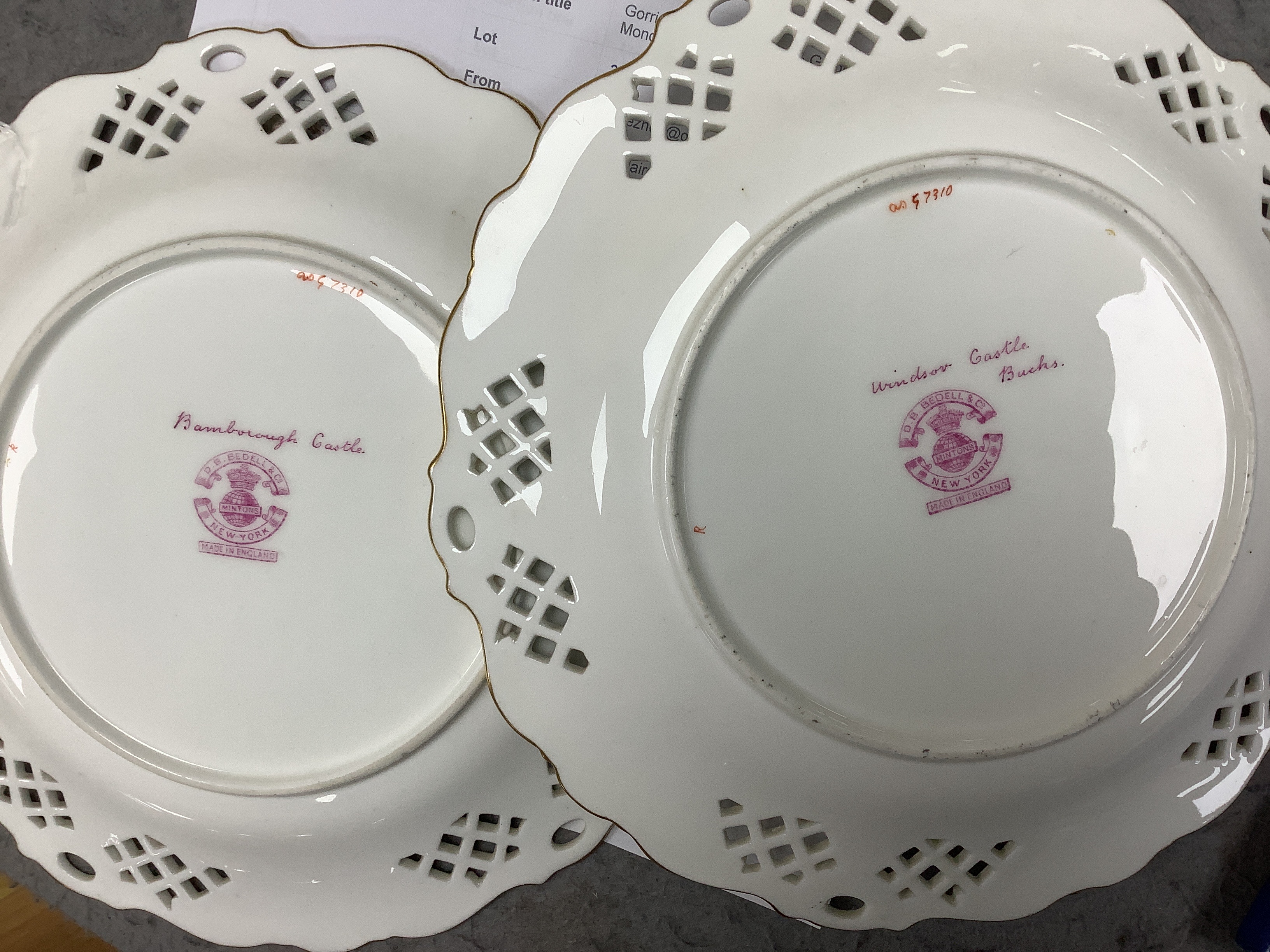 A pair of Mintons bone china dishes, with painted central cartouches of Windsor and Bamborough Castles, 22.5cm diameter